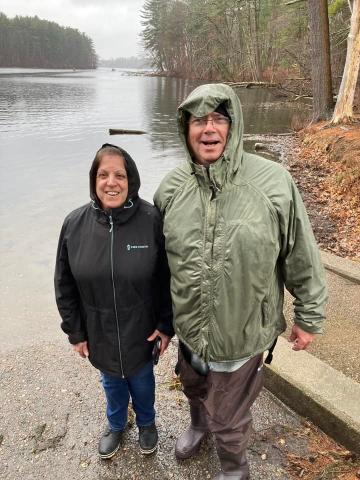 Man and woman posing for photo at lake