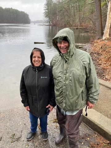 Man and woman posing for photo at lake